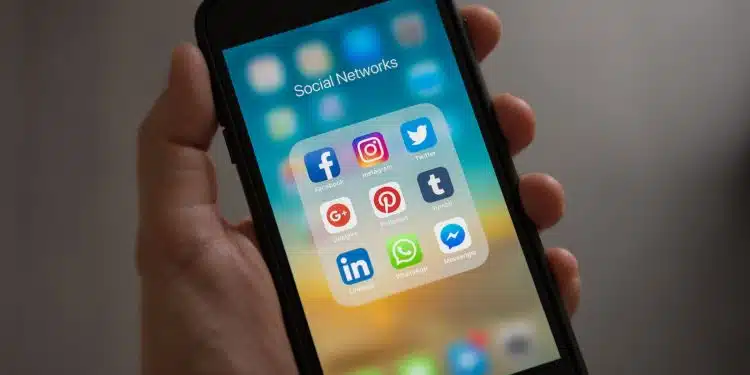 Person Holding Iphone Showing Social Networks Folder